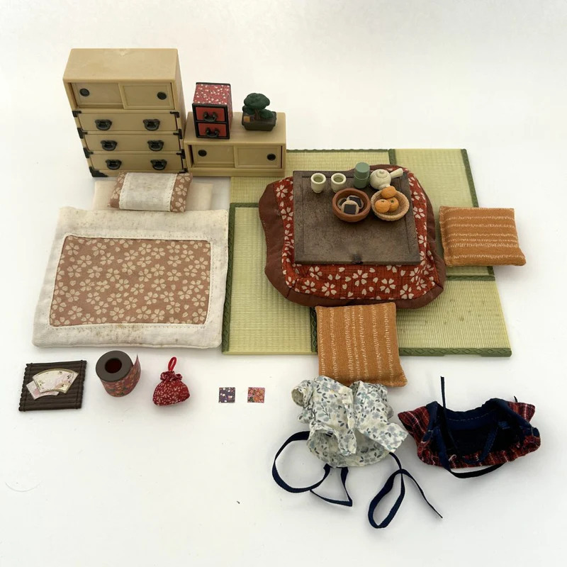 The Sylvanian Families 20th Anniversary Japanese Room Set offers a charming miniature glimpse into traditional Japanese living. It features a low kotatsu table with futon coverings, perfect for gathering and staying warm, along with zabuton cushions for comfortable seating on the tatami mat flooring. The set also includes a tansu chest for storage and a decorative bonsai tree, all evoking a sense of Japanese home decor. This set beautifully represents the importance of communal spaces, floor-level living, and appreciation for natural elements within Japanese culture. &nbsp;