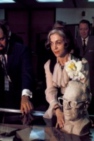 Olga Ley positioning a bust of Willy Ley on a display case.