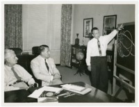 Charles Lundquist briefing Wernher von Braun and Hermann Oberth on satellite orbits.