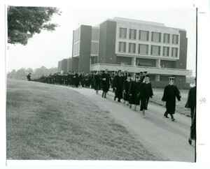 UAH graduates file past Roberts Hall.