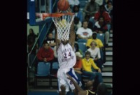 UAH men's basketball player slam dunks during a game.