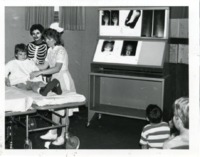 UAH student nurses Valenica Curling and Julia Boehme treat a young patient at Let's Pretend Hospital.