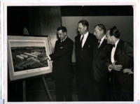 Photograph of officials examining a framed illustration of the University of Alabama Research Institute, Huntsville.