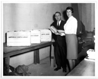 Charlie Chambers of Anderson News and UAH Librarian Christel McCanless pose with book crates of donations to the UAH Library.