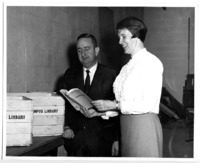 Charlie Chambers of Anderson News and UAH Librarian Christel McCanless pose with book crates of donations to the UAH Library.