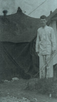 Photograph of a man outside of a tent at the 95th Evacuation Hospital.