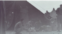 Photograph of men outside with a dog at the 95th Evacuation Hospital.