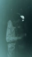 Photograph of a man reading something in a tent at the 95th Evacation Hospital.