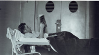 Photograph of a man reading in bed in the 300th General Hospital in Naples, Italy.