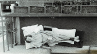 Photograph of a woman reclining on an outside balcony at the 300th General Hospital in Naples, Italy.