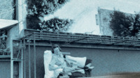 Photograph of a woman reclining on an outside balcony at the 300th General Hospital in Naples, Italy.