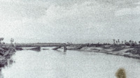 Photograph of a fallen bridge in a river.