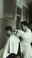 Photograph of a man receiving a haircut at the 300th General Hospital in Naples, Italy.