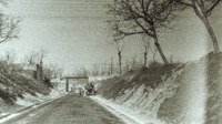 Photograph of a road going underneath a bridge in Italy.