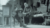 Photograph of two soldiers sitting inside.