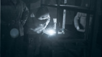 A man welds in the dark as two other look on at the Carolina maneuver area.