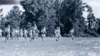 Men running in a field at the Carolina maneuver area.