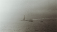 Photograph of the Statue of Liberty and a tug boat.  