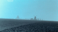 Photograph of French farmland with windmill in the background.