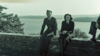 A soldier and a nurse rest on a stone wall, Great Britain.