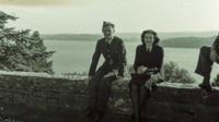 A soldier and a nurse rest on a stone wall, Great Britain.