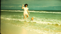 Helen and Dudley Burwell playing in the waves on vacation.