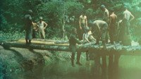 National Guard soldiers at work building a log bridge.
