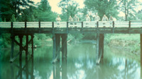 Soldiers on a wooden bridge at a National Guard camp.